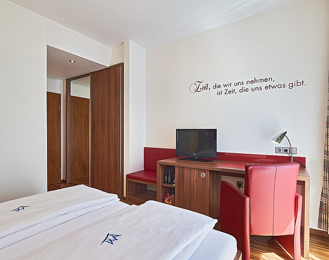Gemütliches Zimmer mit Schreibtisch und TV – stilvolle und praktische Hotelzimmer am Bodensee.