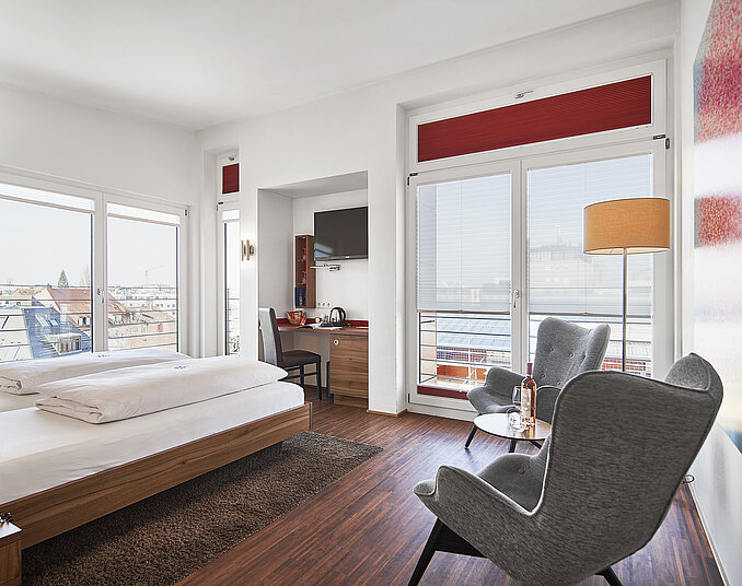 Modernes Hotelzimmer mit Blick auf den Bodensee und gemütlicher Sitzecke mit Tagungsräumen am Bodensee.