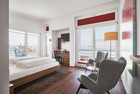 Modernes Hotelzimmer mit Blick auf den Bodensee und gemütlicher Sitzecke mit Tagungsräumen am Bodensee.
