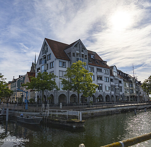 Historische Häuserfassade am Ufer der Friedrichshafener Altstadt bei sonnigem Wetter.
