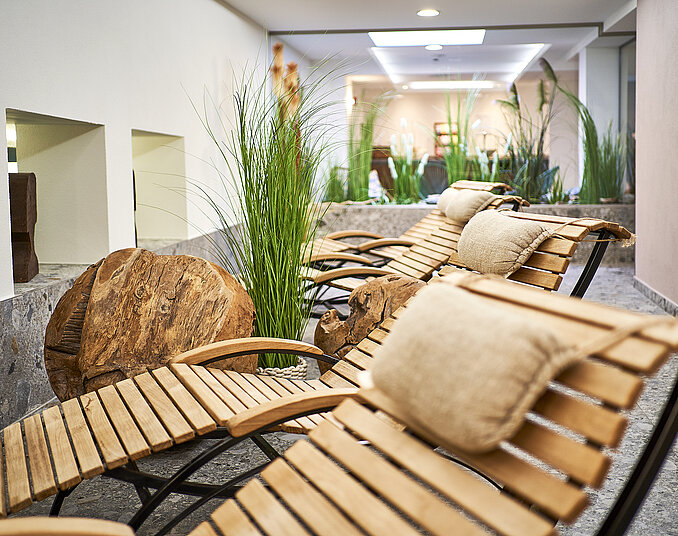Bequeme Holzliegen mit Kissen im Ruheraum – natürliche Entspannung und Wellness in Friedrichshafen.