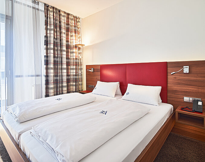 Gemütliches Doppelbett mit modernem Design – stilvolle Hotelzimmer am Bodensee entdecken.