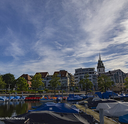 Blick auf den Hafen von Friedrichshafen mit Booten im Vordergrund .